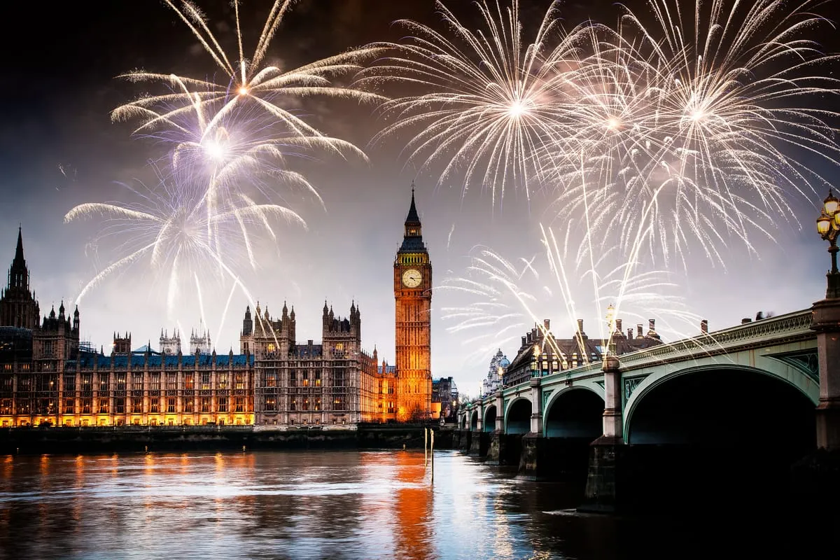 Fireworks over the Houses of Parliament, Big Ben and Westminster Bridge, reflected in the River Thames