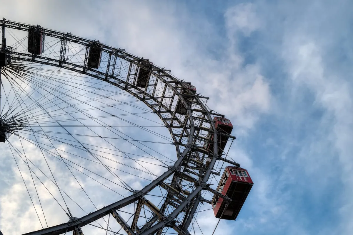 Red cabins on the steel frame of the Vienna Giant Ferris Wheel in the Prater against a cloudy sky