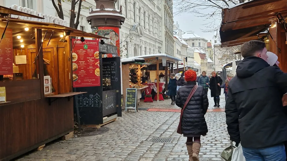 Wooden market huts and shoppers on a cobbled lane at the Spittelberg Christmas market in Vienna